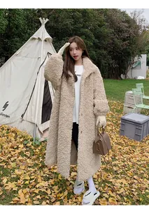 Asian female model wearing a long beige teddy fleece coat in an outdoor autumn setting
