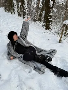 Eleganter langer silberner Kunstpelzmantel für Damen in einer verschneiten Winterwaldlandschaft