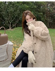 Outdoor shot of a cozy long beige teddy fleece coat with stand-up collar