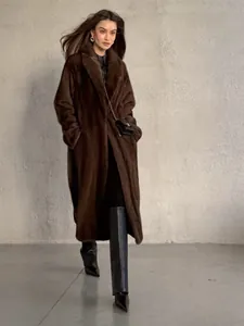 Detailed view of women's long dark brown faux fur coat with mink-like texture