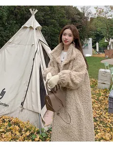 Long beige teddy shearling coat for women styled in an outdoor winter camping scene