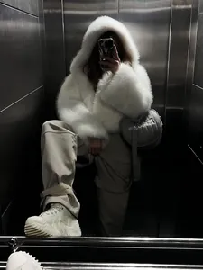 Detailansicht einer weißen Kunstpelz-Kapuzenjacke in einer stylischen Spiegel-Selfie-Pose