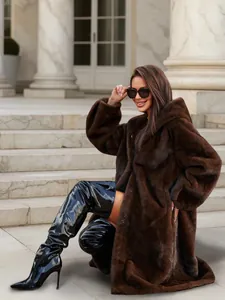 Model posing in a chic long brown faux fur hooded coat on classic outdoor stone steps