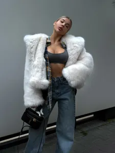 Kaukasisches Model in weißer Webpelzjacke mit Kapuze im angesagten Streetwear-Look