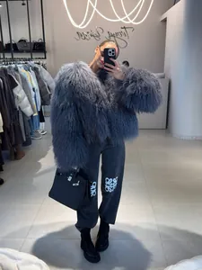 Close-up of grey long-haired faux fur jacket shown in a boutique mirror selfie