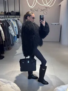 Detail of a luxurious black Tan sheep wool faux fur coat worn in a high-end boutique