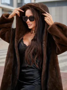 Stylish woman in premium dark brown long faux fur hooded coat for winter fashion.