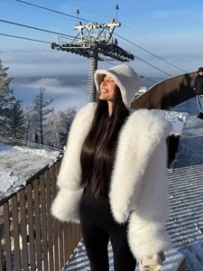 Elegant white faux fur coat for women with large lapels in a snowy winter landscape.