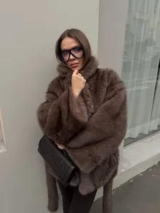 Elegantes Modell in einem hochwertigen braunen Webpelzmantel mit Gürtel in einer Straße