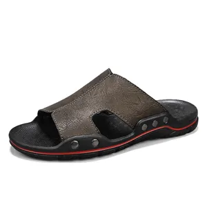 Heren slippers van bruin leer met antislipzool en decoratieve klinknagels voor de zomer.