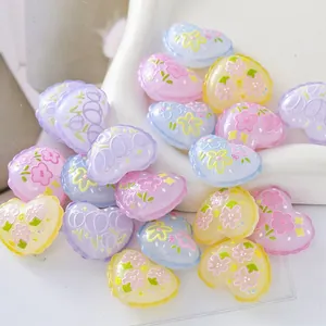 Close-up macro view of pastel embossed heart beads with floral prints for DIY jewelry