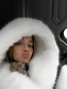Détail de la capuche en fausse fourrure blanche d'un manteau d'hiver élégant porté par un mannequin