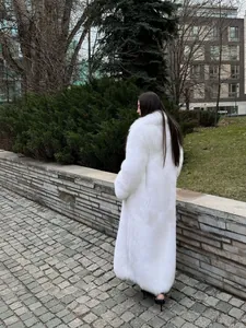 Vista posteriore di un lungo e lussuoso cappotto in pelliccia sintetica bianca chic