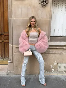 Schicker rosa Kunstpelzmantel kombiniert mit hellem Denim für einen modischen Look