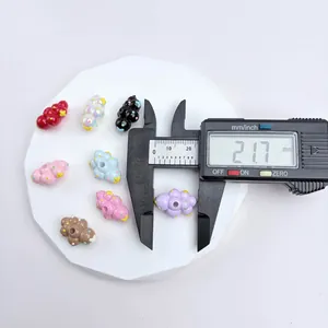 Hand-painted cloud shaped beads being measured with digital caliper at 21.7mm size
