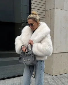 Elegante weiße Kunstpelzjacke mit flauschigem Schalkragen, präsentiert im Freien von Model
