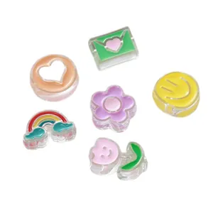 Colorful oil-dripped acrylic beads in heart, rainbow and smiley shapes for DIY crafts.