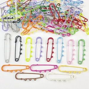 Detail view of colorful painted large safety pins with charm loops for DIY crafts