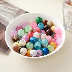 Cuentas de acrílico de colores con agujeros grandes en un cuenco de cerámica blanca
