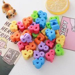 Macro view of vibrant candy-colored ampersand-shaped acrylic beads for DIY jewelry crafts.