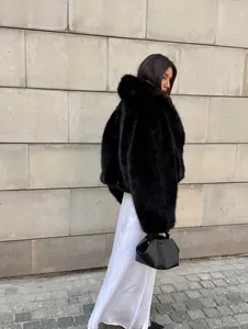 Eleganter schwarzer Kunstpelzmantel für Damen mit Schalkragen, gezeigt in einer Außenumgebung