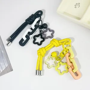 Detalle de llaveros creativos de cuerda de cuero DIY con amuletos de estrellas y eslabones