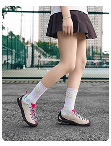 Nahaufnahme stilvoller beiger und pinker Outdoor-Wanderschuhe auf einem Sportplatz