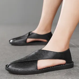 Close-up of black leather hollow loafers with cross-strap and handmade stitching