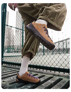 Detailaufnahme von hellbraunen Outdoor-Wanderschuhen mit lila Schnürsenkeln in Außenumgebung.