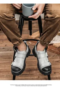 Detailed shot of stylish men's leather round-toe Martin work shoes worn on a wooden stool.