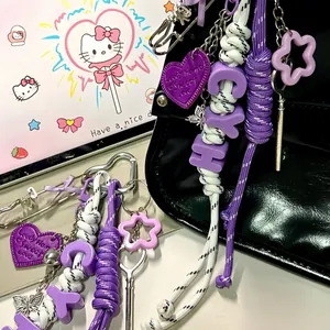 Detail view of a purple 5mm DIY woven paracord bag charm with heart and star accents.