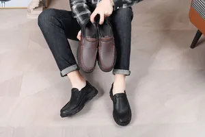 Close-up detail of men's slip-on loafers in black and brown pebble grain leather