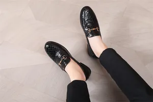 Detailansicht der schwarzen geflochtenen Leder-Loafer mit goldener Schnalle am Boden.