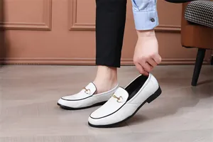 Nahaufnahme weißer Herren-Loafer aus geprägtem Leder mit goldener Trensenspange