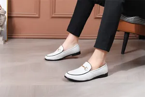 Detailaufnahme von weißen Herren-Loafers mit Textur und goldener Schnallenverzierung