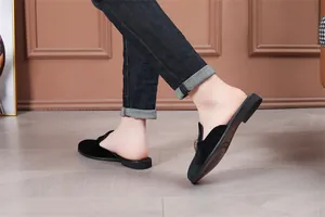 Κομψά ανδρικά μαύρα βελούδινα loafers χωρίς φτέρνα, σε πλάγια όψη κατά το περπάτημα