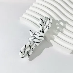 Detail view of 5mm white and black braided polyester rope for DIY crafts and bag straps.