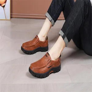 Vue portée de mocassins en cuir marron avec semelles en caoutchouc antidérapantes.