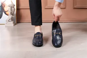 Detailaufnahme von eleganten marineblauen Flechtlederslippern mit goldener Trense