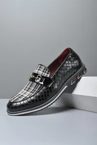 Detalle de mocasines de hombre en cuero trenzado negro con diseño de cuadros y hebilla