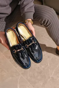 Detailansicht von schwarzen Lackleder-Loafers für Herren mit goldenem Trensen-Detail