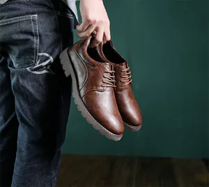 Makroansicht brauner Leder-Derby-Schuhe mit strukturierter Oberfläche und Schnürung.