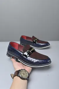 Detalle de mocasines para hombre en cuero trenzado azul con hebilla dorada