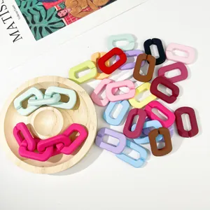 Macro-detail van diverse kleurrijke mat acryl U-vormige kettinglinks voor DIY sieraden maken.