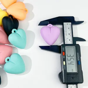 Macro view of a 35.4mm colorful acrylic heart pendant measured with digital caliper