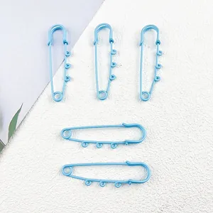 Detailed macro view of light blue painted large safety pins with small loops for DIY accessories