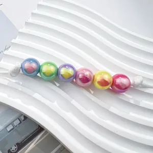 Close-up of colorful pearlescent acrylic beads with UV heart pattern for DIY jewelry making
