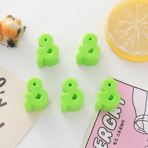 Detailed macro view of bright green acrylic ampersand beads for DIY jewelry making and crafts