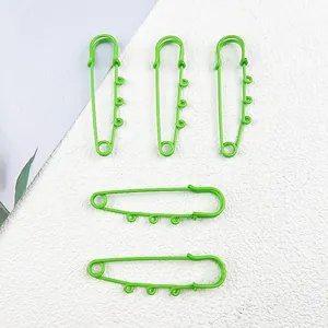 Close-up of bright green safety pins with triple loops for DIY jewelry and bag charms