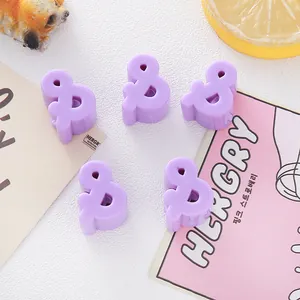 Detailed view of purple 6mm acrylic ampersand beads for DIY jewelry making.